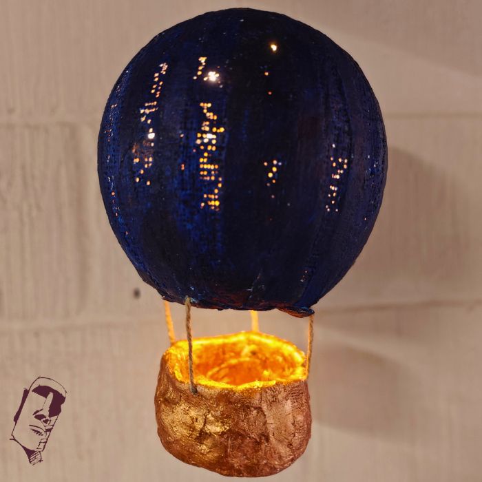 Luftballon i gipsgaze med bl ballon og bronze kurv op af hvid vg.