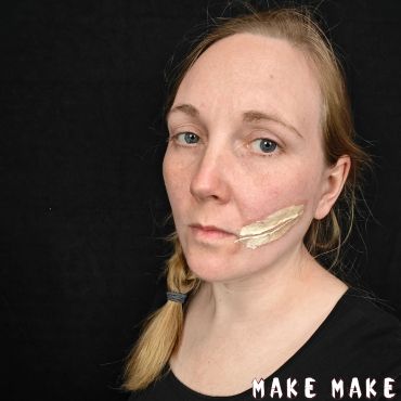 Kvinde hvis ansigt er malet med flydende latex p kinden til et fake sr.