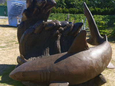 ConcreteClay sculpture representing a shark with a wave of fish